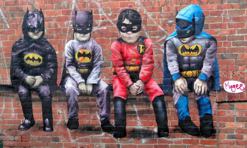 Fintan Magee street artwork on brick wall of super hero kids